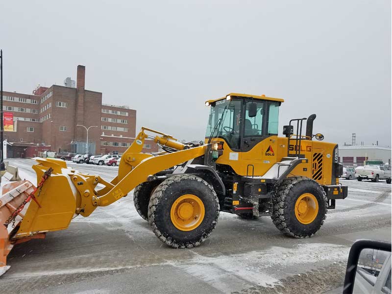 Front end loader plowing snow
