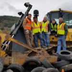 Men wearing safety vests standing on bulldozer