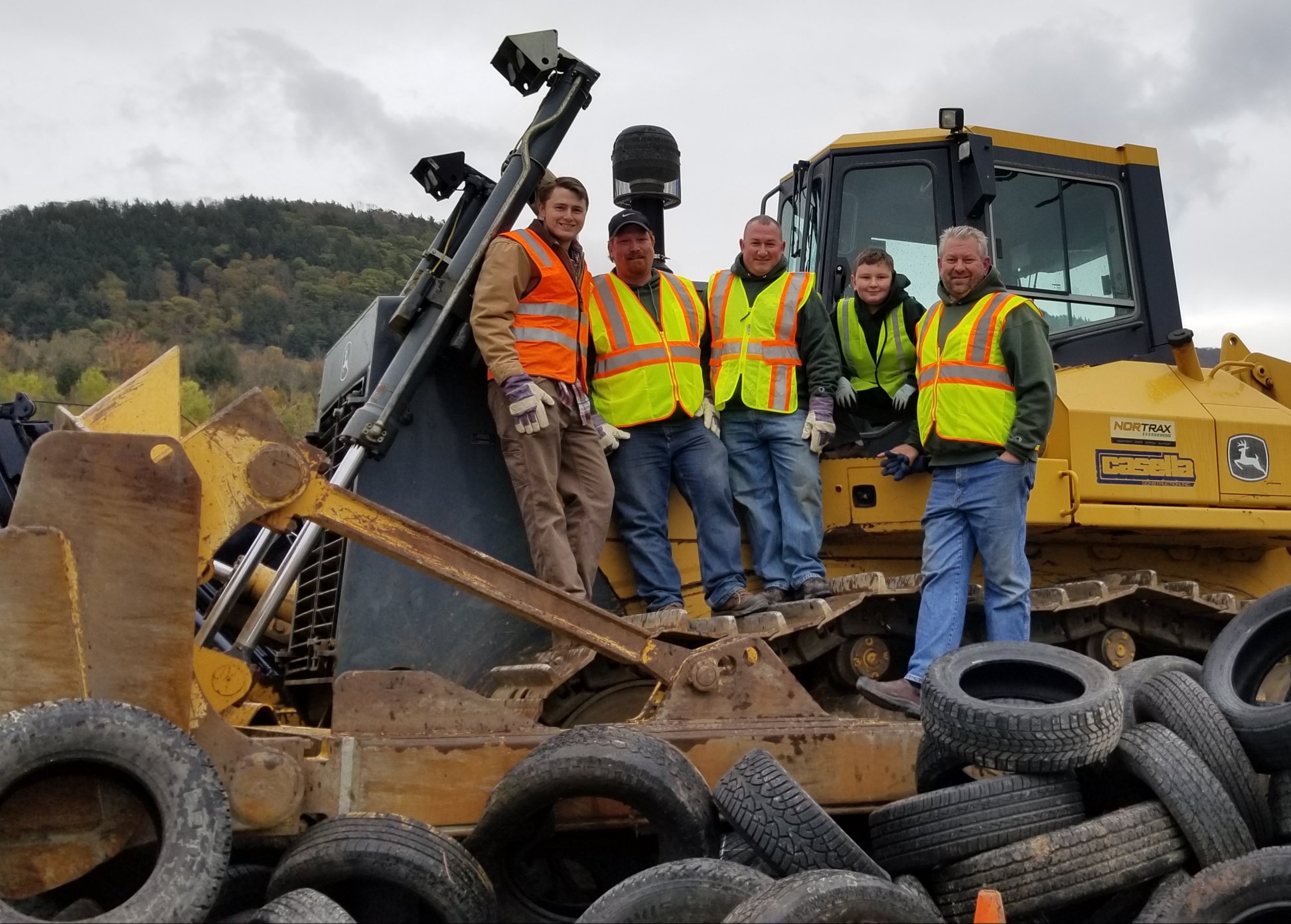 Men wearing safety vests standing on bulldozer